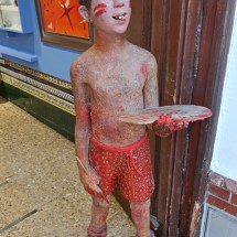 Boy at the entrance of the gallery No 27 Pintada street in Nerja which shows paintings and other works of Francisco Martin